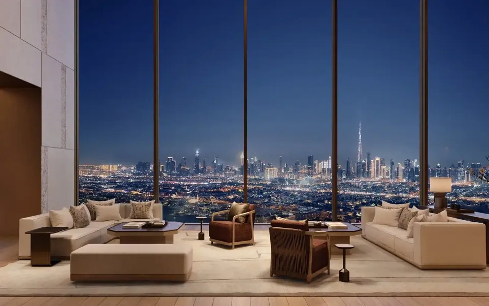 Spacious living room at Aman Residences Dubai with floor-to-ceiling windows framing the city skyline, neutral furnishings, and warm accent lighting.