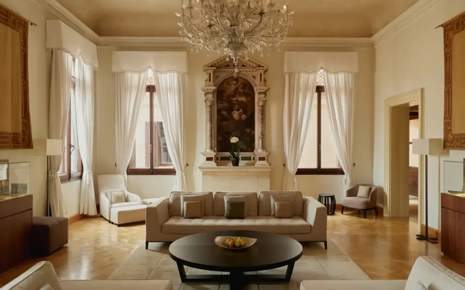 Living area in Coccina's apartment at Aman Venice, with elegant furnishings and tall windows overlooking the city.
