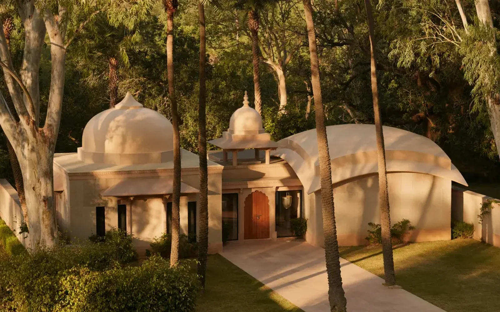 Pool pavilion at Amanbagh surrounded by trees at dusk, India.