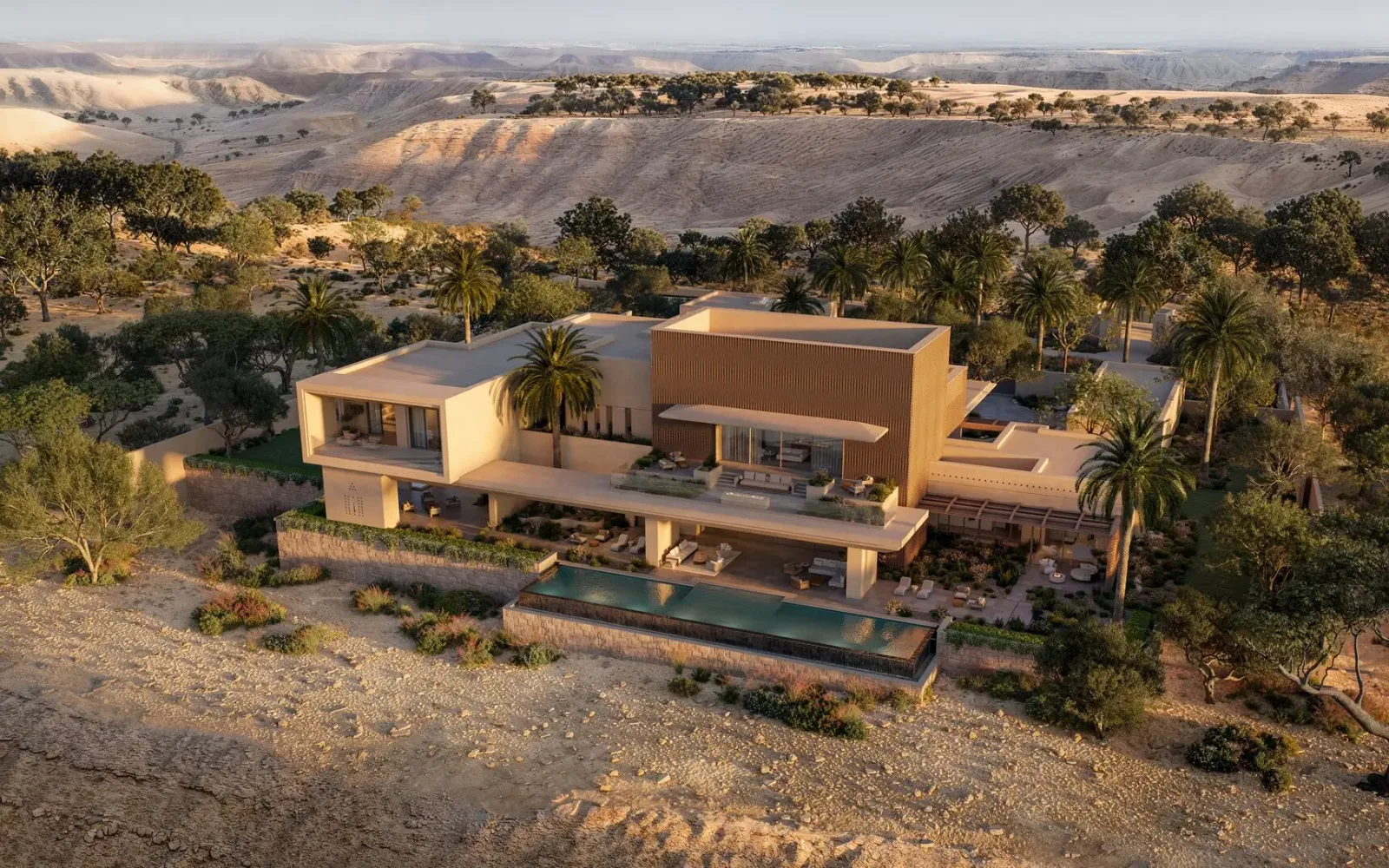 Aerial view of Amansamar's contemporary architecture set among palm trees in the Wadi Safar desert landscape.