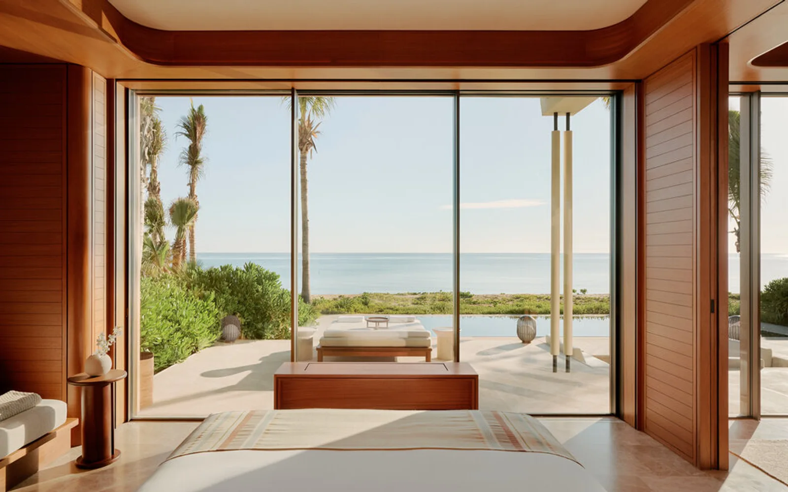 Amanvari accommodation with floor-to-ceiling windows overlooking Mexican landscape and terracotta seating.