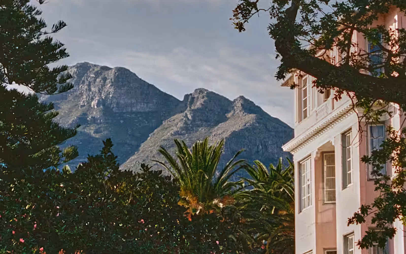The contours and ridges of the mountain ranges create dramatic scenery behind the manicured elegance of the hotel.