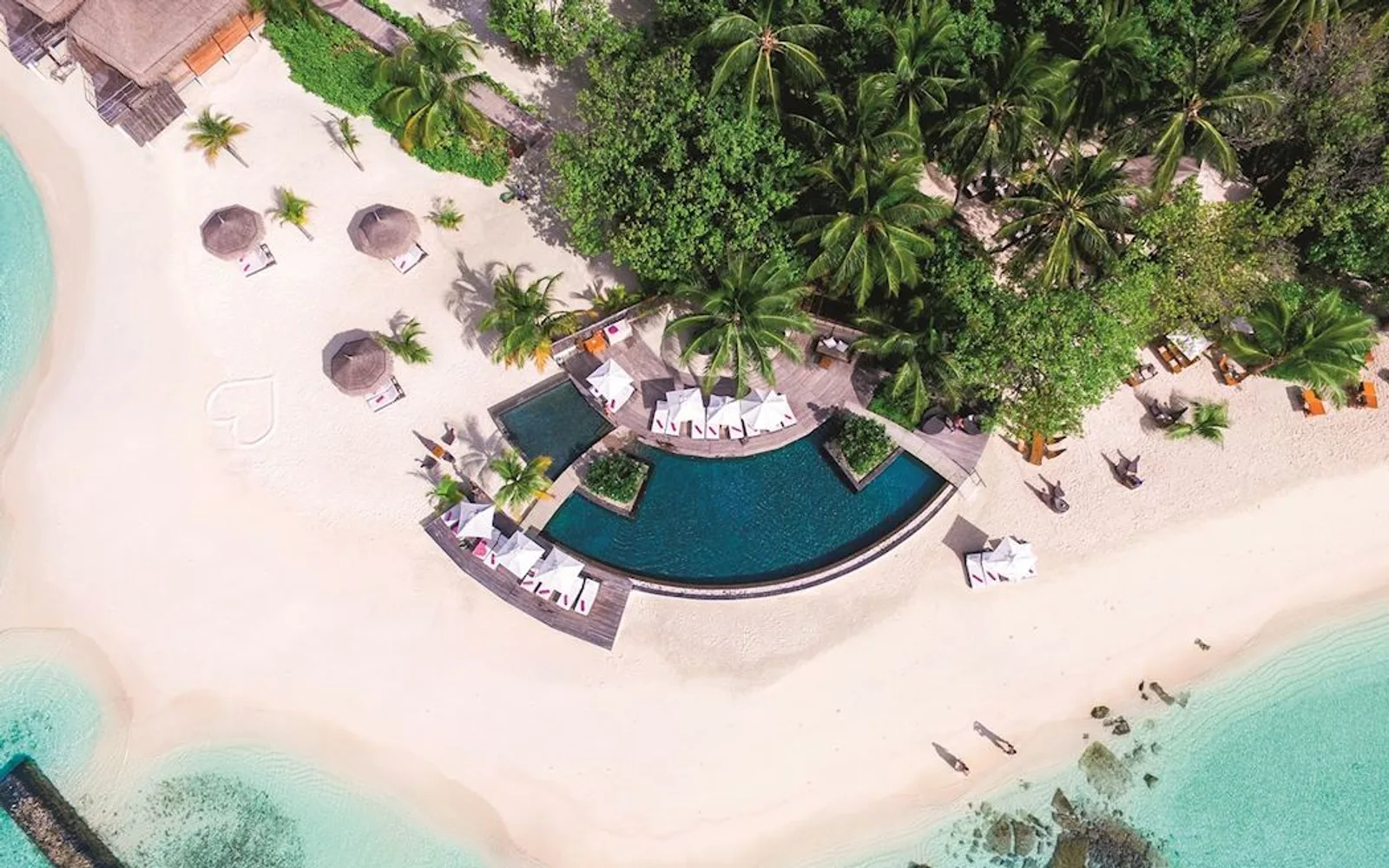 The beach and curved pool at Constance Moofushi.