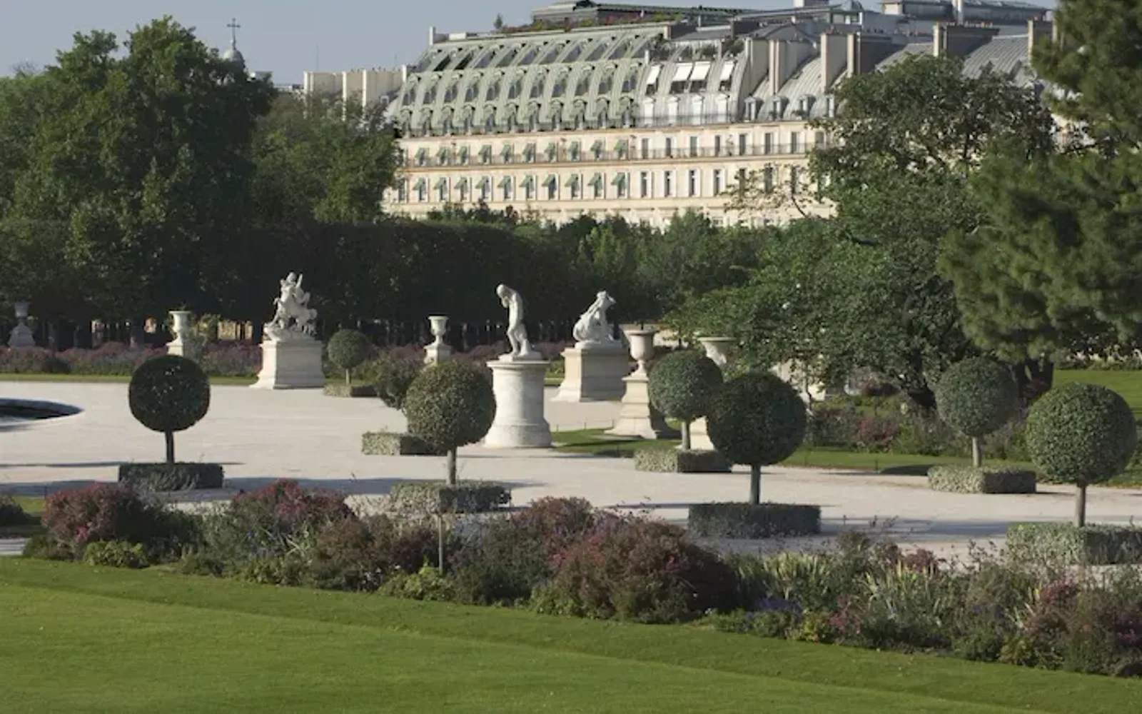 Distant view of the hotel from the Tuileries Garden point of view, showing the top part of the façade and the green shades, at the Tuileries Gardens, Paris.