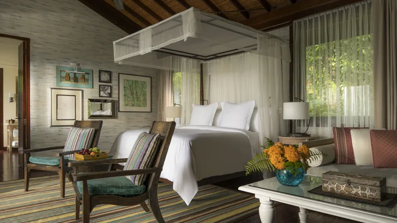 Villa bedroom with a canopied bed at Four Seasons Resort Seychelles