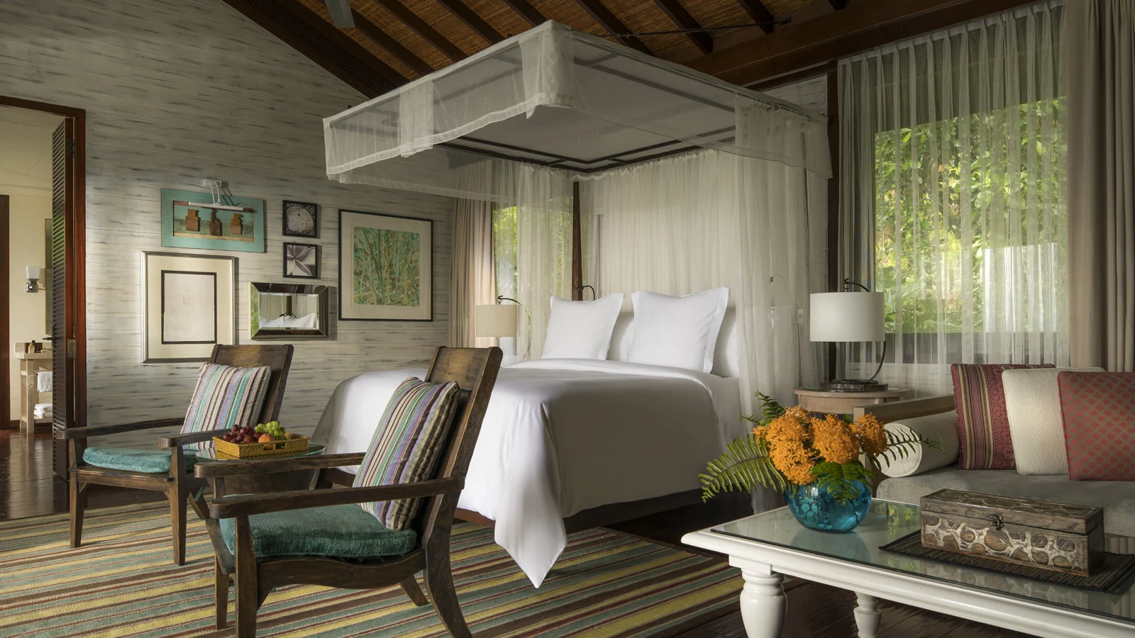 Villa bedroom with a canopied bed at Four Seasons Resort Seychelles