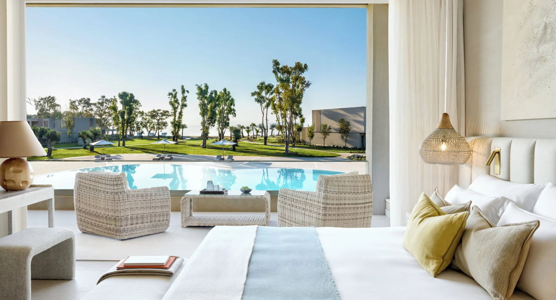 Suite bedroom overlooking the pool and gardens at Ikos Odisia