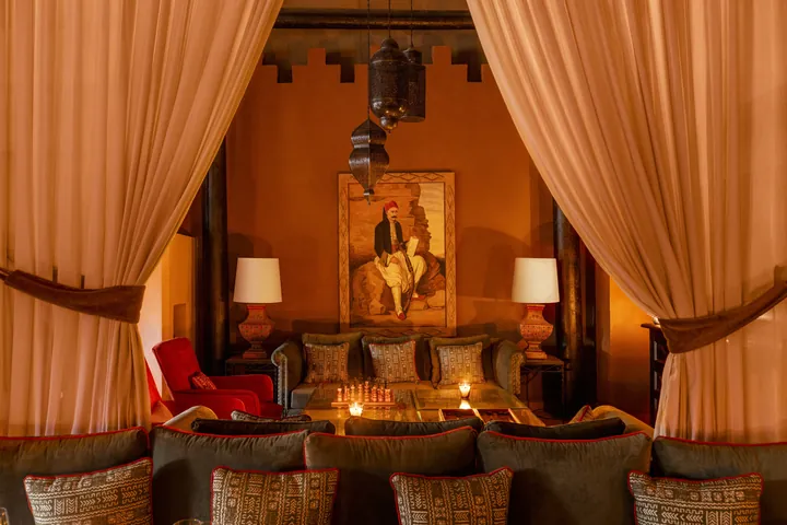 Cushioned lounge beneath draped curtains at Kasbah Tamadot