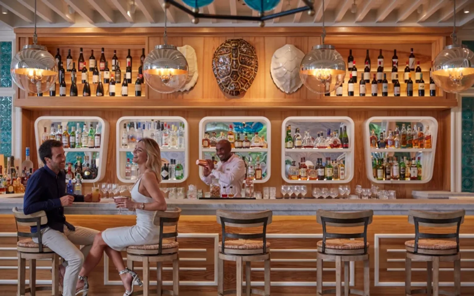 A couple sharing a candid moment over cocktails at Tides Bar, Mandarin Oriental, Canouan.