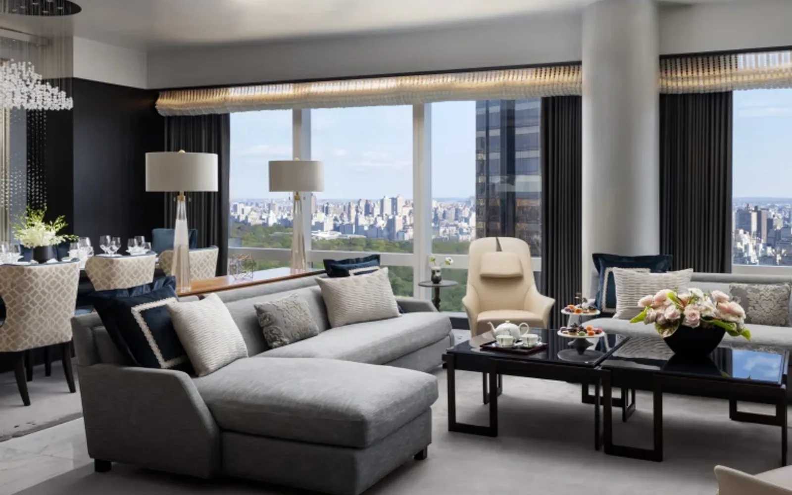 A view of a suite living room with a city skyline view from the windows