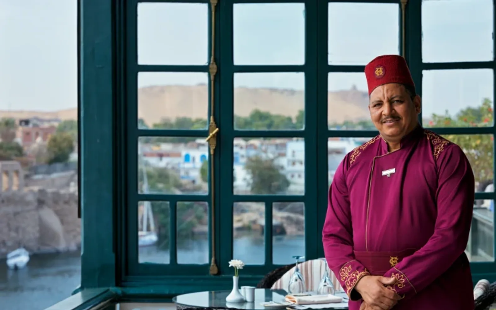 Colleague standing in outdoor seating area overlooking the Nile at Terrace restaurant, Old Cataract, Aswan.