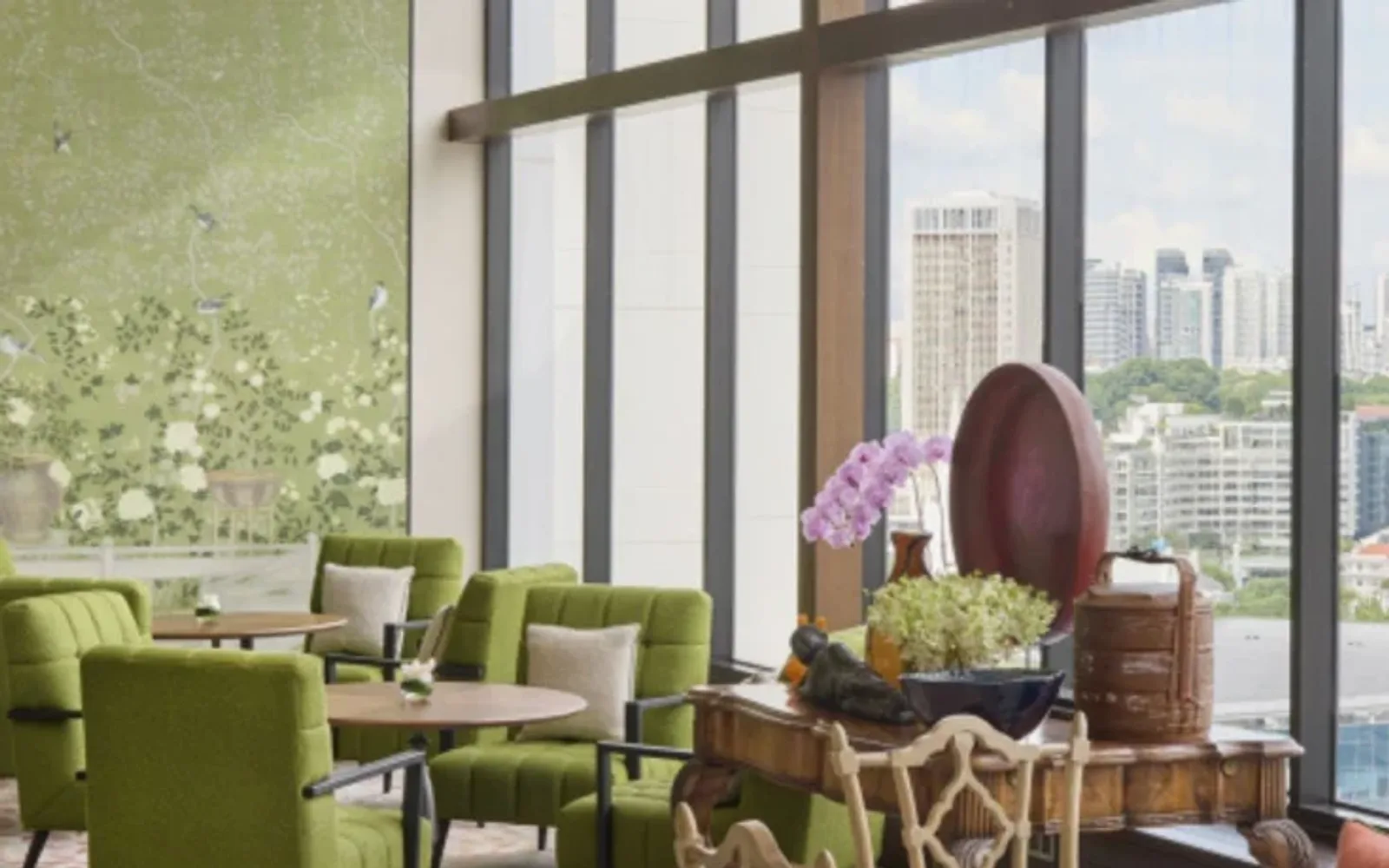 Private lounge area with sofa seating and a floor-to-ceiling window overlooking the city at Mandarin Oriental, Singapore.