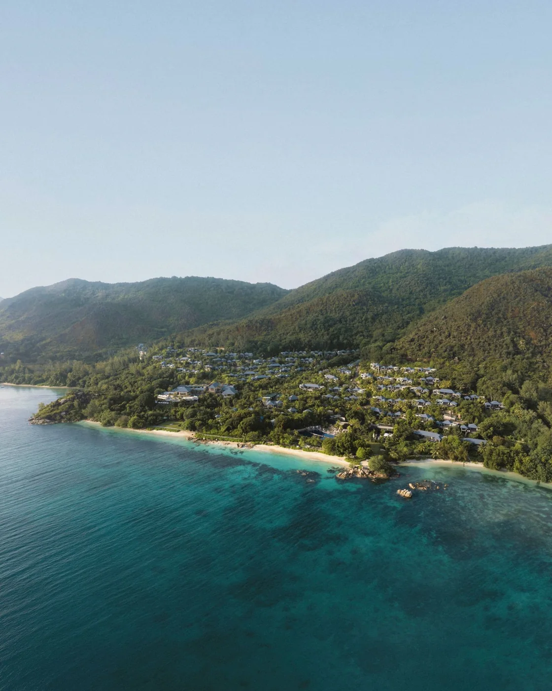 The coastline and hillside setting of Raffles Seychelles