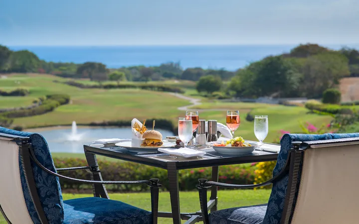 An outdoor dining table overlooking the golf course at Sandy Lane, Barbados