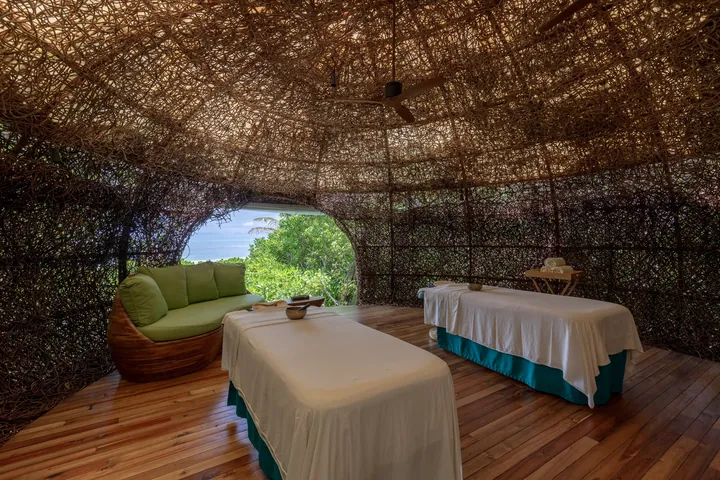 Woven spa treatment nest with two massage beds at Six Senses Laamu